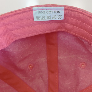 Label on Pink Baseball hat stating that it is 100% cotton