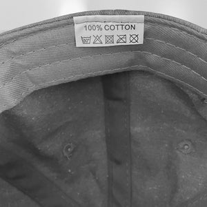 Label on Cancer baseball hat stating that it is 100@% cotton